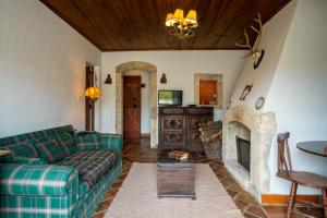 a living room with a couch and a fireplace at Quinta do Brejo - Turismo Equestre in Mafra