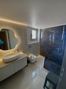a bathroom with a sink and a toilet and a mirror at Acqua Blu Blu apartment in Koroni