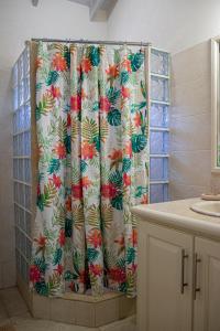 a shower curtain with a floral pattern in a bathroom at Best E Villas Providence in Christ Church
