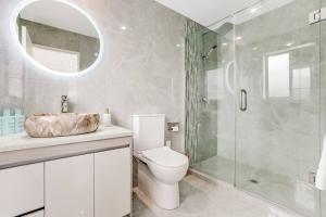 un bagno con wc e doccia in vetro di 5 BDR Flat Bush Mansion - Central Aircon, Fast WiFi, Pool Table, Netflix and More! ad Auckland Altre 16 foto
