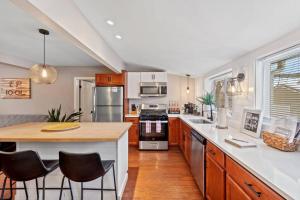 eine Küche mit Holzschränken und eine Insel mit Barhockern in der Unterkunft Charming PLX Cottage-LAKE VIEW in Akron