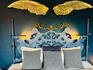 a bedroom with a bed with a blue and gold headboard at Palm View Guesthouse, adults only in Luz