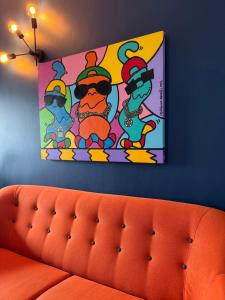una pintura en una pared sobre un sofá naranja en Palm View Guesthouse, adults only, en Luz