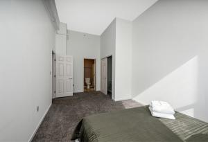 een slaapkamer met witte muren en een bed bij Prkg+Sauna+Gym near Rock & Roll Hall of Fame in Cleveland