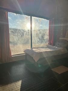 a bedroom with a bed and a window with a view at Mozoon camp in Wadi Rum