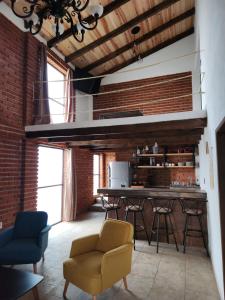 a living room with a brick wall and a table and chairs at Villa Nidawi by Natut Huasca in Huasca de Ocampo