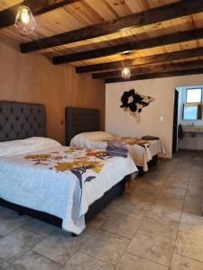 two beds in a room with wooden ceilings at Villa Nidawi by Natut Huasca in Huasca de Ocampo