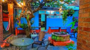 a patio with a table and chairs and a tree at Casa isabel in Santa Ana