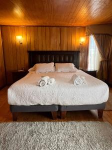 1 dormitorio con 1 cama con 2 toallas en Hostal Florencia, en Hornopirén