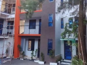 un edificio de apartamentos con puertas y ventanas azules en EQUATOR GATES HOTEL Bulega, en Bulenga