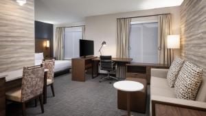 ein Hotelzimmer mit einem Bett, einem Schreibtisch und einem Zimmer in der Unterkunft Residence Inn by Marriott Denver Aurora in Aurora