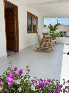 Mykonos Beach House في تولو: غرفة معيشة مع الزهور الأرجوانية وكرسي