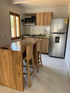 uma cozinha com uma mesa de madeira e um frigorífico em Mykonos Beach House em Tolú