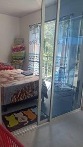 a bedroom with a glass door leading to a bed at Cabaña Mi Chelita in Ibagué