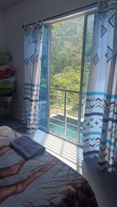 a bedroom with a window with a view of a balcony at Cabaña Mi Chelita in Ibagué