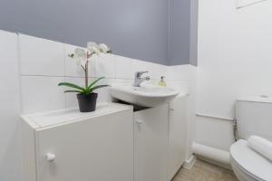 a white bathroom with a sink and a toilet at Newly refurbed, 5BR, Sleeps 12 in Northampton