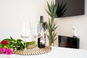 a bottle of wine and two glasses on a table at Northern Hideaways, Lockup Mews in Bellingham