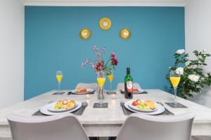 a dining room table with plates of food and drinks at Newly refurbed, 5BR, Sleeps 12 in Northampton