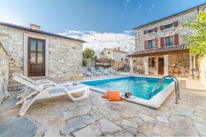 a pool with two lounge chairs and a house at Villa Major near Vrsar and Lim Fjord in Marasi