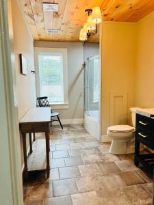a bathroom with a toilet and a sink and a shower at The Tellico Plains Inn and Event Venue in Tellico Plains