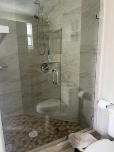 um chuveiro com uma porta de vidro na casa de banho em Habitación luminosa y acogedora. em Hollywood
