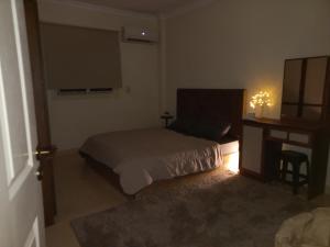 sypialnia z łóżkiem, komodą i biurkiem w obiekcie Joe Excellence Residence w Kairze