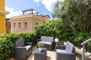 eine Terrasse mit 2 Stühlen, einem Tisch und einem Gebäude in der Unterkunft Appartamento San Pietro-Vaticano in Rom