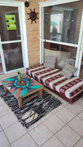 a porch with a couch and a coffee table at Maré Alta Hostel in Ubatuba