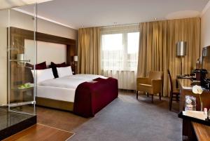 a hotel room with a bed and a desk and chair at Flemings Hotel Frankfurt Main-Riverside in Frankfurt