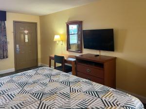 a bedroom with a bed and a desk and a television at Motel 6 Morrilton, AR in Morrilton