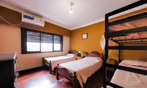 a room with three bunk beds and a window at COYA HOSTEL in Salta