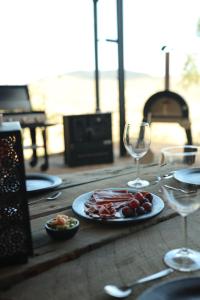 - une table en bois avec une assiette de nourriture et des verres à vin dans l'établissement Residencia Artistica CasaVino, à Casablanca