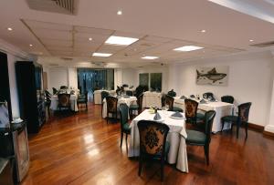 a dining room with white tables and chairs at LUOXO Hotel in Lima