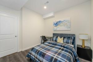 a bedroom with a bed and a desk with a lamp at Private basement bedrooms in Oakville in Oakville