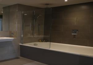Modern New Spacious Apartment في كرويدون: حمام مع دش وحوض استحمام