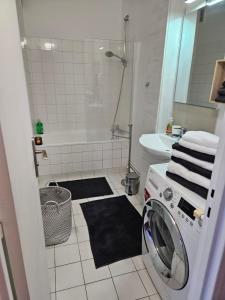 une salle de bains blanche pourvue d'un lave-linge. dans l'établissement HOME PARIS TOUR EIFFEL, à Paris