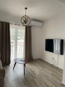 a living room with a table and a flat screen tv at Darija in Dobra Voda