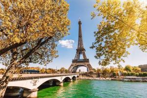 un pont sur une rivière avec la tour eiffel dans l'établissement HOME PARIS TOUR EIFFEL, à Paris