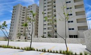 a large apartment building with trees in front of it at Sol y mar in Boca del Río
