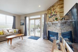 a living room with a fireplace and a couch at Lazy Lookout on Devils Lake in Lincoln City