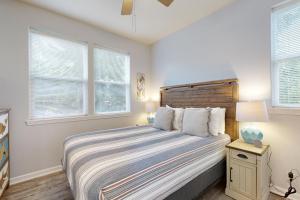 een slaapkamer met een bed met een houten hoofdeinde en ramen bij Lazy Lookout on Devils Lake in Lincoln City