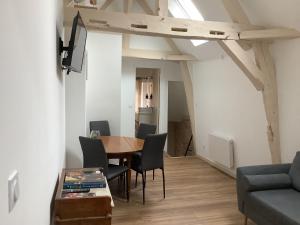 a living room with a table and chairs and a couch at Maison cœur de Chablis in Chablis