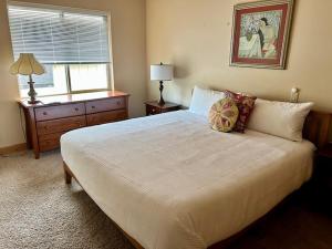 Skyliner Trails home في بيند: غرفة نوم مع سرير أبيض مع خزانة ملابس ونافذة