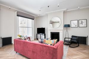 a living room with a red couch and a tv at Sonder King Street in London