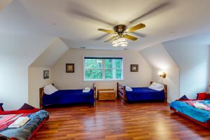 a living room with two beds and a ceiling fan at Still Waters in Moneta