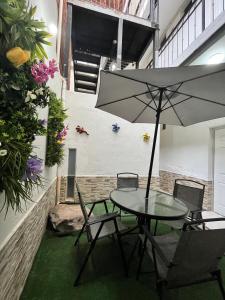 a table and chairs with an umbrella in a courtyard at Hotel Juarez 70 in Colima