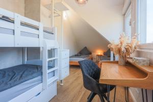 - une chambre avec des lits superposés et une table en bois dans l'établissement DreamStay Augsburg Traum Penthouse Göggingen, à Augsbourg