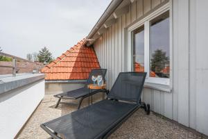 two chairs and a table on a balcony at DreamStay Augsburg Traum Penthouse Göggingen in Augsburg