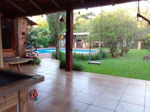 un patio avec une balançoire et une piscine dans l'établissement Casa de Campo em Santa Rosa - RS, à Santa Rosa