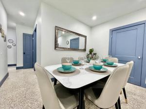 a dining room with a white table and chairs at Renovated Villa resort pool, BBQ and Ping Pong Patio in Tamiami